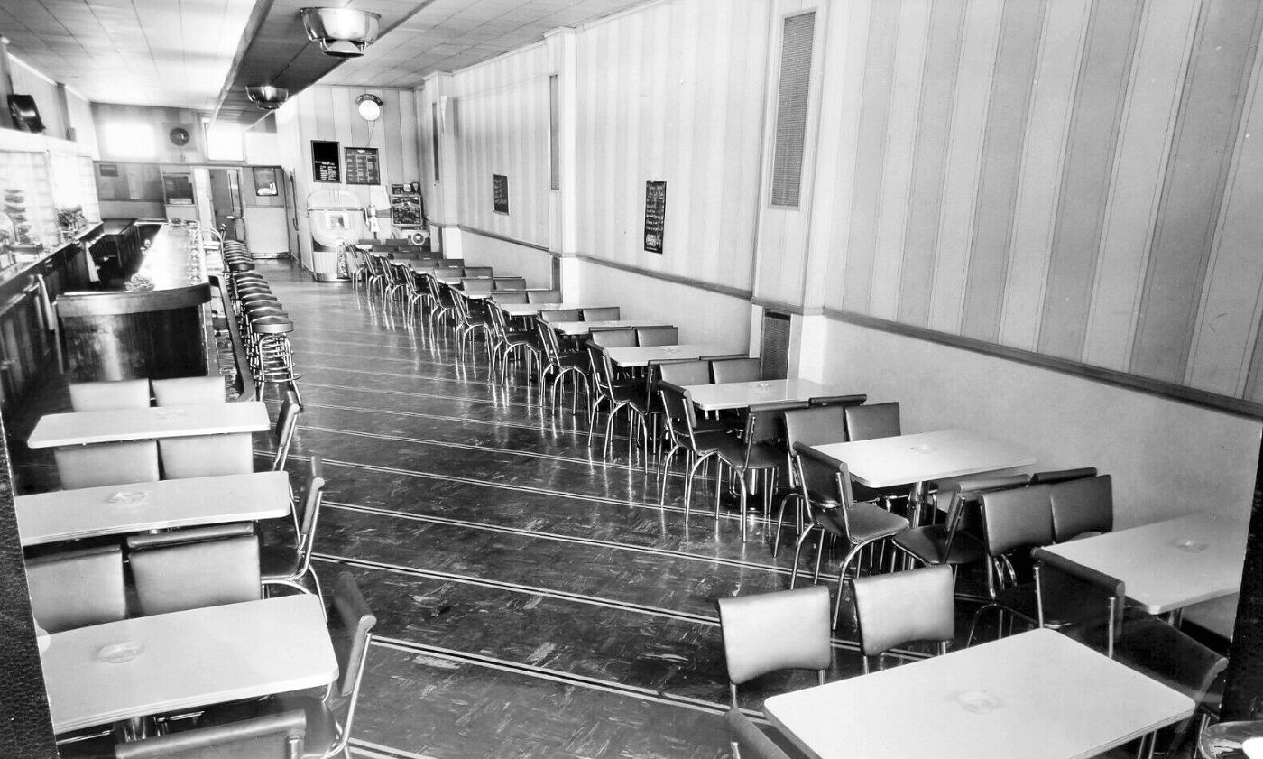 Tiger's Café on North Sixth Street, Allentown, in 1939: a lunch counter with stools on the left and rows of empty tables along an aisle.